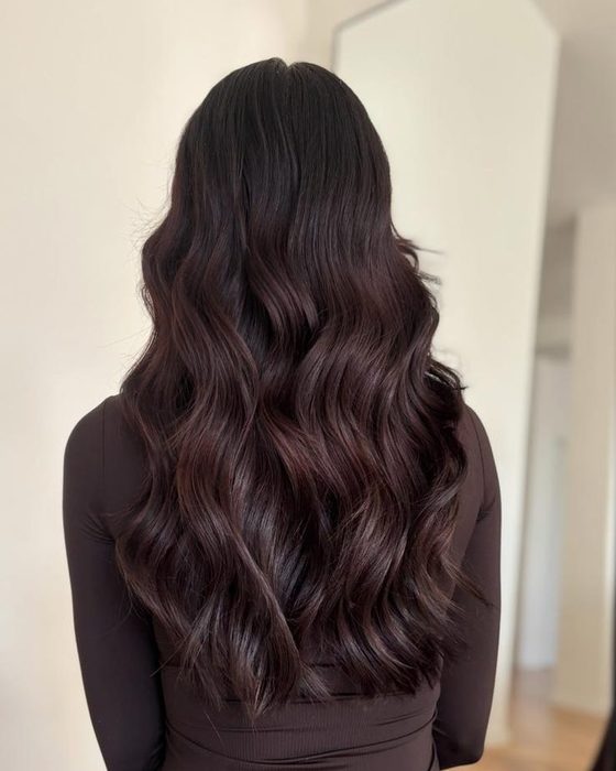 Gli stessi capelli dopo le extension a tessitura: lunghezza fino alla vita, mossi e voluminosi