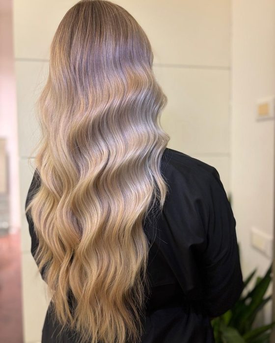Capelli lunghi biondi con onde morbide e schiariture fredde
